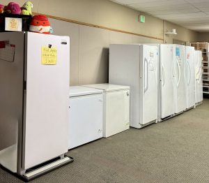 Long row of white freezers inside Packed with Pride